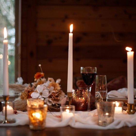 white taper candles paired with muted florals and smaller tealights and votives