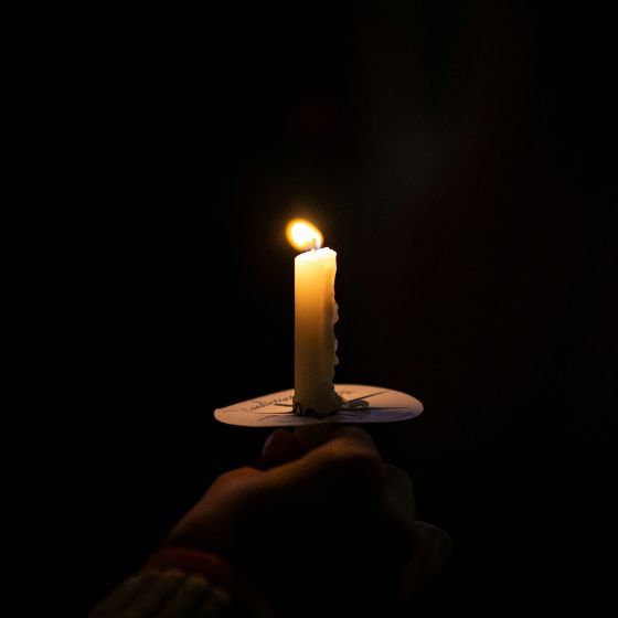 person holding a taper candle with a bobeches