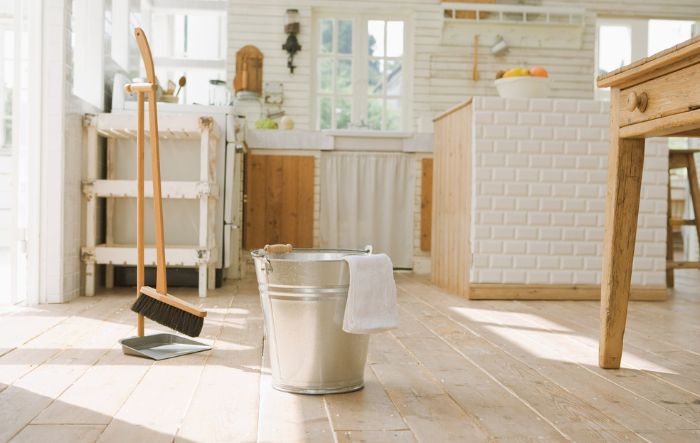 bucket with towel and broom with a dustpan in a clean kitchen