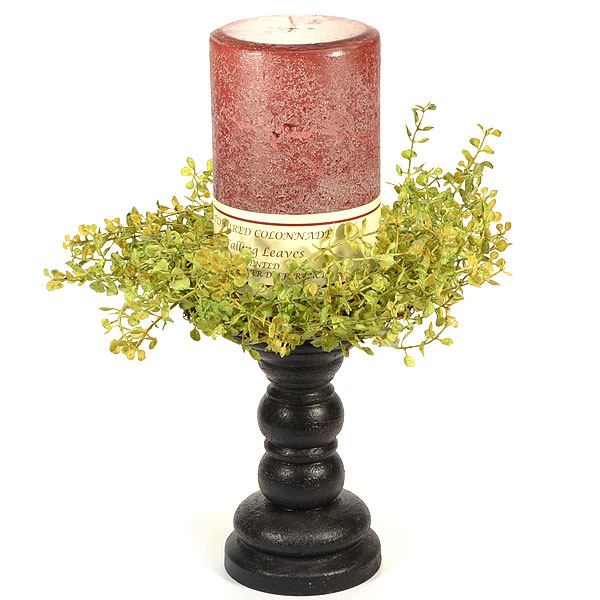 pillar candle on a holder with a decorative ring